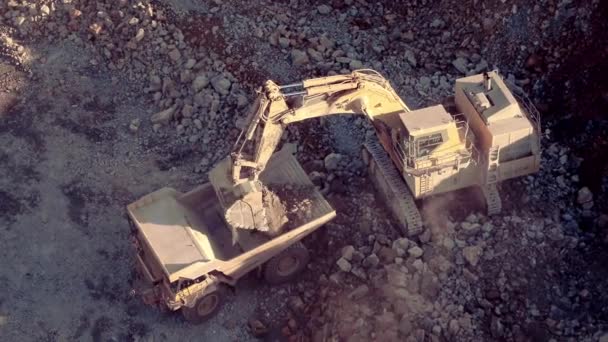 リオティントグループが所有する銅オープンピットにトラックをダンプする岩をアンロードする大規模な掘削機の静的なショット — ストック動画