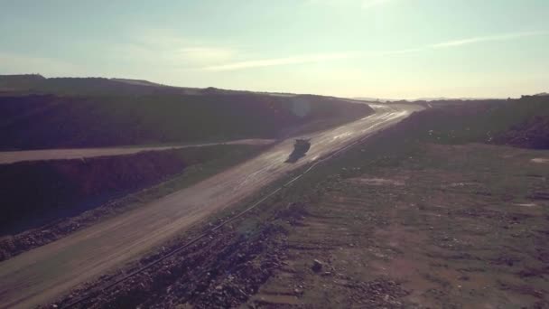 リオティントグループの銅鉱山のような火星内部の湿った未舗装の道路に乗っている長距離トラックのショットでのパララックス追跡 — ストック動画