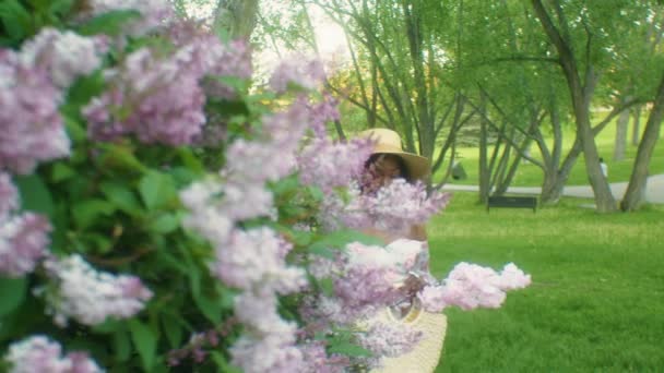 Mooie Zwarte Jonge Vrouw Ruiken Bloemen Lilacs Glimlachen Oogcontact Close — Stockvideo