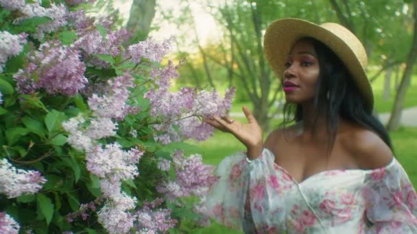 Black Woman Smelling Flowers Lilacs Smiling Eye Contact — Vídeos de Stock
