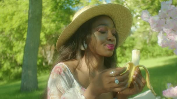 Negro Mujer Comer Banana Masticar Parque Dolly Primer Plano — Vídeos de Stock