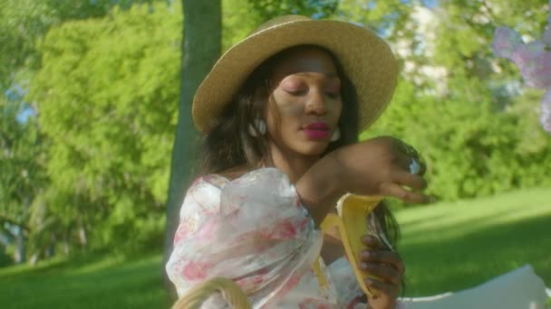 Black Woman Calmly Peeling Banana Picnic Park Close — Video