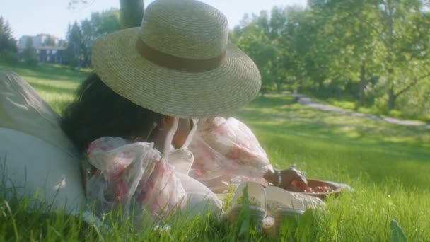 Zwarte Vrouw Draagt Zonnehoed Liggend Haar Zij Picknick Het Park — Stockvideo