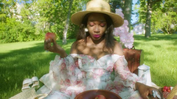 Чорна Жінка Їсть Яблуко Коригує Волосся Пікніку Парку — стокове відео