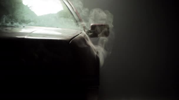 車のフロント 煙のセット上の赤い車のフードの下から来る 暗い大気中のショット — ストック動画