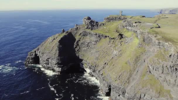 在阳光明媚的日子里 爱尔兰的著名悬崖峭壁高耸入云 用石塔巫婆的头飞向草地覆盖的悬崖 海浪冲击着岩石海岸和石层形成的悬崖 — 图库视频影像