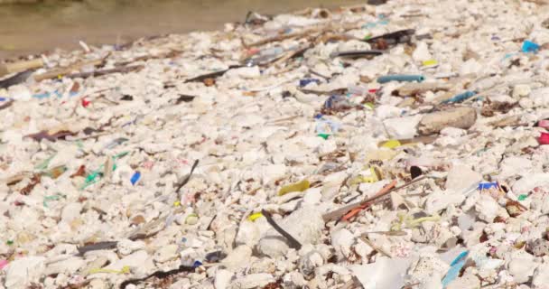 加勒比地区岩石海岸上的静态三脚架正在缓慢地冲刷着塑料碎片和垃圾 — 图库视频影像