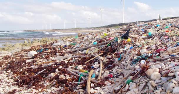 加勒比海岸岩石上的静止不动的广袤的人渣正在缓慢地冲刷着塑料碎片和垃圾 — 图库视频影像