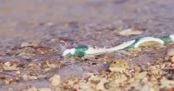 Крупним Планом Пластикова Стара Зубна Щітка Вимита Піщаному Пляжі Змивається — стокове відео