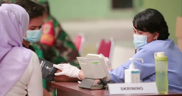 Mladá Doktorka Kontroluje Krevní Tlak Pacienta Nosí Masku Před Očkováním — Stock video