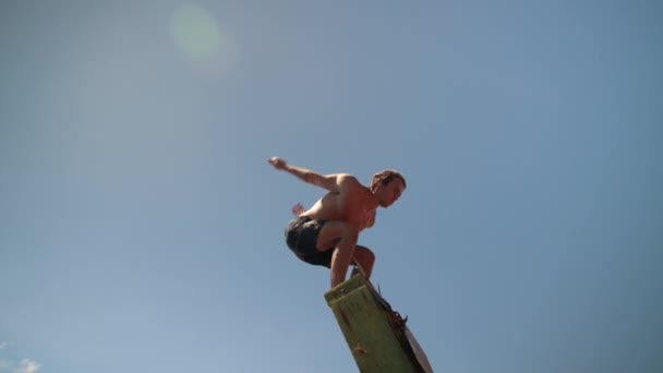 Красивый Молодой Человек Прыгающий Назад Океанскую Воду Высокой Лестницы Скале — стоковое видео