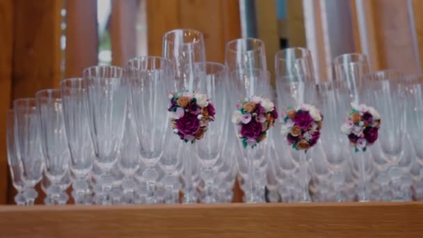 Zblízka Sledovat Záběr Prázdných Sklenic Šampaňského Zdobené Květinami Dřevěném Stole — Stock video