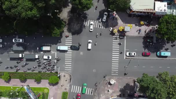 ベトナムのホーチミン市の交差点を横断する数百台のバイクや車のドローンのタイムラプス トップダウンビュー — ストック動画
