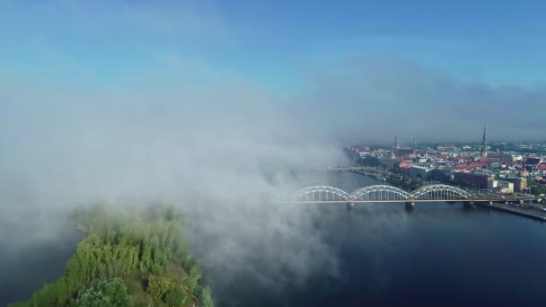 ラトビアのリガ 鉄道橋 ドーガヴァ川と都市景観 ドローンショットの上の朝の霧の空中ビュー — ストック動画