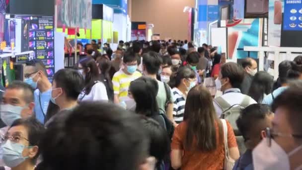 コンピュータフェスティバルで ハードドライブ テレビ ラップトップなどの割引電子製品を購入するための廊下を通って閲覧する中国の顧客の大群衆の傾きショット — ストック動画