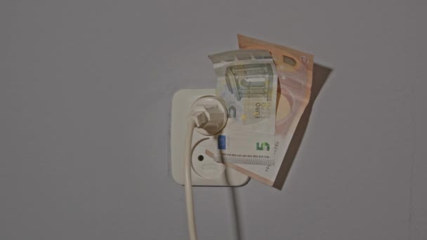 エネルギー危機の概念 電気コンセントへのプラグによって開催されているユーロ紙幣のズーム — ストック動画