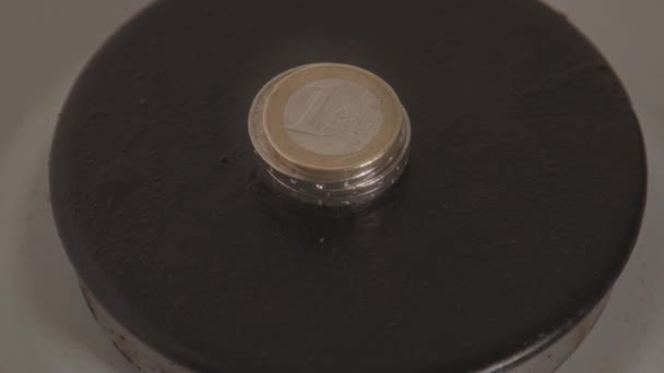 エネルギー危機の概念 燃焼ガスストーブの上に横たわるユーロ硬貨のスタックからズームアウト — ストック動画