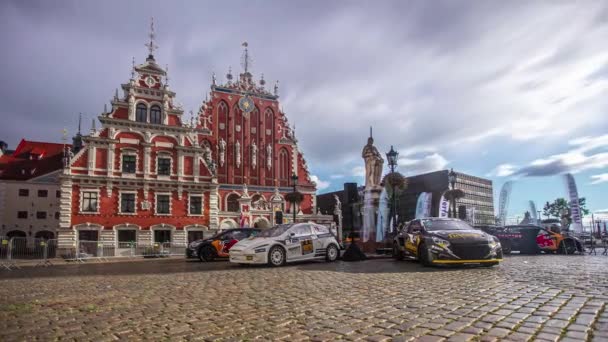 昼間のRx World Rally Cross Championshipでラトビアのリガの古い歴史的建造物の前に展示されているレースカーのショット — ストック動画