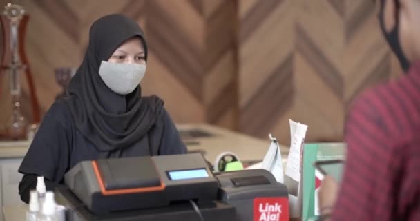 咖啡店收银台 女性零售经理接受一位年轻男性顾客为咖啡支付的Nfc智能手机和信用卡付款 — 图库视频影像
