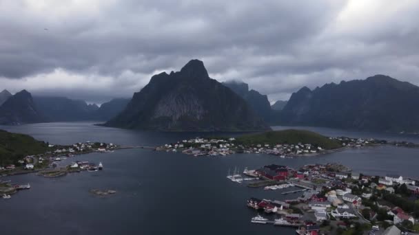 ノルウェーの険しい崖ノルウェーのノルトランド郡のフィヨルドと海に囲まれた島々にあるReinebringen山とReine漁村 航空機を確立 — ストック動画