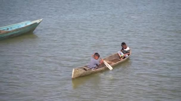 子供たちはボートでビーチで遊んでいます 幸せな家族のファンタジー子供の夢のコンセプト ボートを漕ぐことで遊ぶ子供たち インドネシア スラウェシ州ケンダリ海で — ストック動画