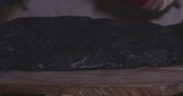 Сырое Тесто Деревянном Столе Покрытое Черным Пластиком Закрыть — стоковое видео