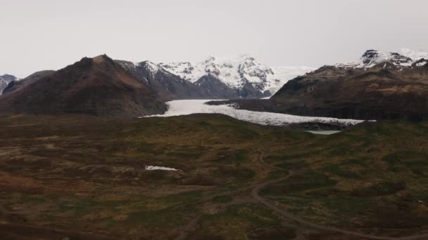 雪と岩とアイスランドの氷河の空中前方ドローン映像 — ストック動画