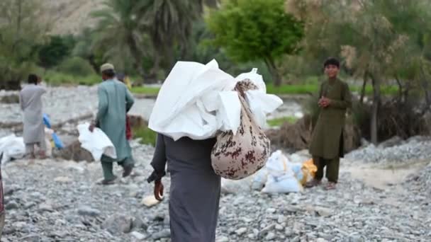 Vader Draagt Zak Van Hulp Wit Zeil Balochistan Tijdens Zondvloed — Stockvideo