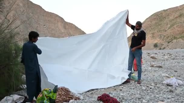 Video Shows Two People Spreading White Plastic Sheet Pebble Filled — Vídeo de stock