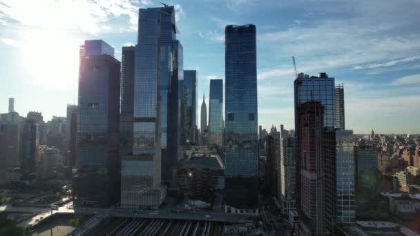 晴れた日に遠くにエンパイアステートビルとハドソンヤードの空中ビュー マンハッタンの西側のガラスの建物に向かってカメラがドリー — ストック動画