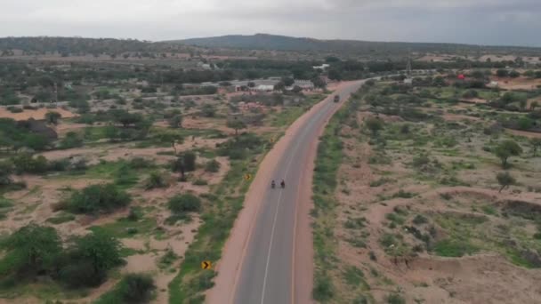 Drohne Schießt Uhrzeigersinn Auf Zwei Radfahrer Die Auf Der Autobahn — Stockvideo