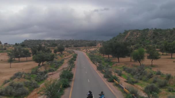 在巴基斯坦信德省的Tharparkar公路上 两名骑自行车的人驾驶自行车 Drone从空中拍摄了这条孤立的公路 — 图库视频影像
