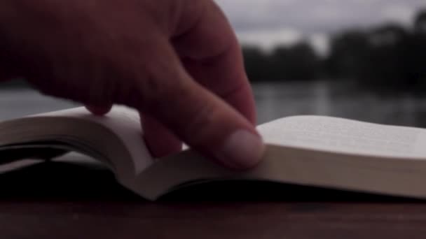 Text Book Table Overlooking Lake Hands Turning Pages — Vídeo de stock