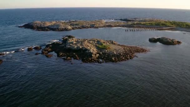 遠くの無人偵察機は桟橋の近くにオープン海洋隔離された岩の島を表示 ニューポート — ストック動画
