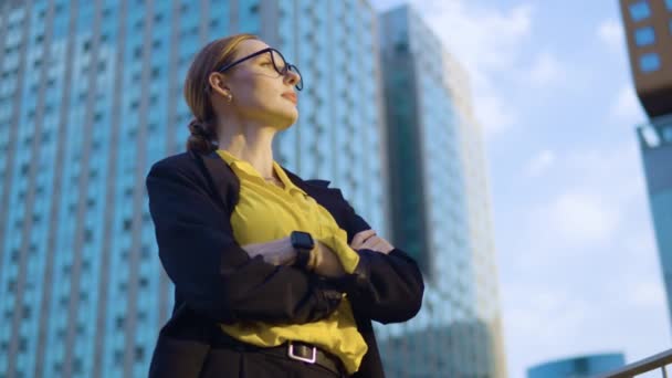 自信的首席执行官年轻商业女性交叉着双臂仰望夕阳西下 面对高楼大厦 女性独立和领导力 慢动作 — 图库视频影像