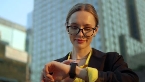 スマートウォッチを見て メッセージや電子メールをチェックするためにタッチスクリーンを使用してスタイリッシュな企業の労働者のビジネスマンの女性 — ストック動画