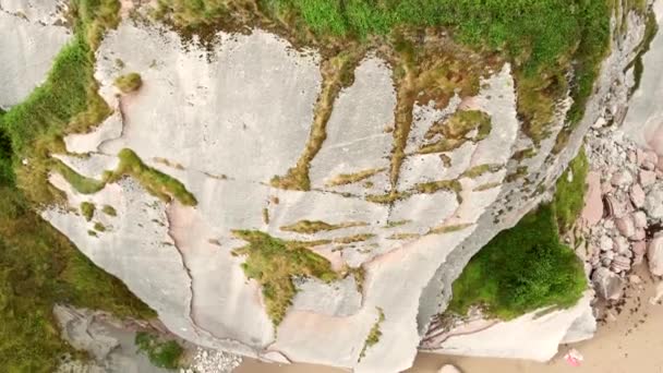 从上到下拍摄悬崖 展示人们在令人叹为观止的伊祖伦海滩上放松身心的情景 — 图库视频影像
