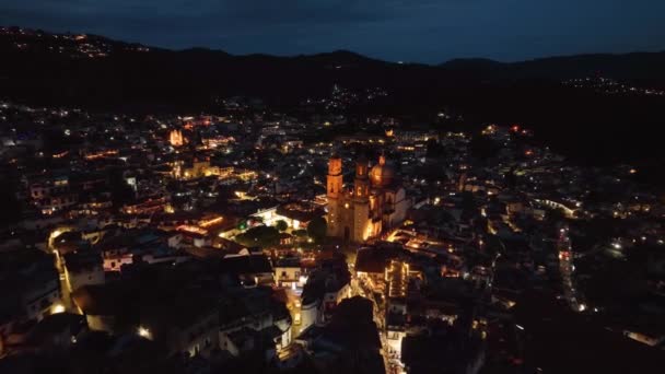 教会に近づくタスコ ゲレロのライトアップされた街並みを見下ろす空中ビュー メキシコの夜 — ストック動画