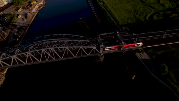 空中侧向平底锅 上有钢制拉桥 列车日落时通过 — 图库视频影像
