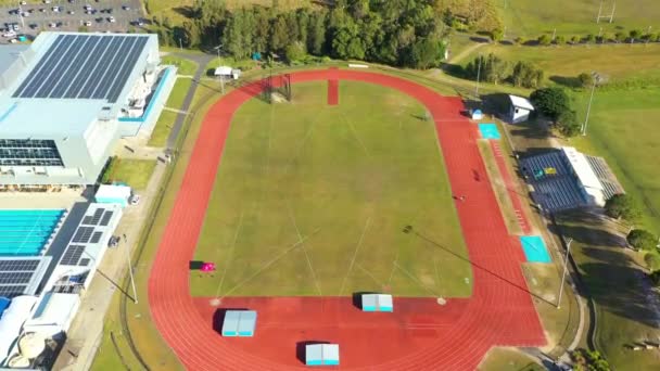 Drone Aéreo Por Encima Pista Atletismo Universidad Roja Con Edificios — Vídeo de stock