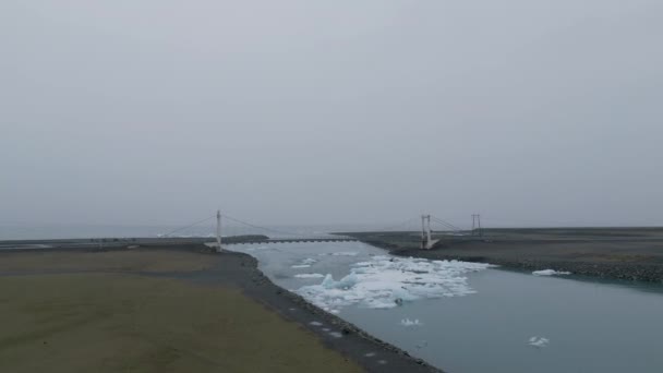 アイスランドのダイヤモンドビーチの近くにあるジョクルサロン氷河ラグーンの橋 — ストック動画