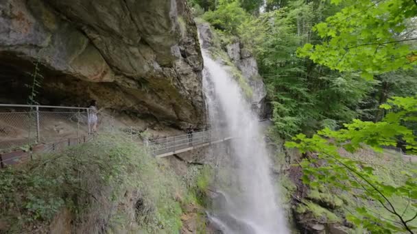 スイスのGeissbach滝の下の橋の上の人々 — ストック動画