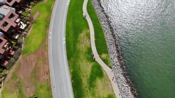 沿着海岸线与人同行的空中自上而下的小径 骑自行车在海湾边的小径上 加利福尼亚州提伯伦 — 图库视频影像