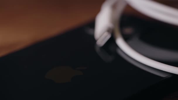 苹果Iphone智能手机背面的Usb C电缆的Rack焦点在桌子上 — 图库视频影像