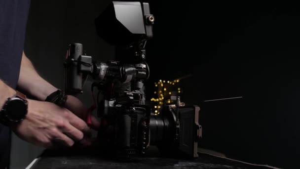 Kamera Operatörünün Sinema Kamerasındaki Ekstra Ekipmanları Çıkartırken Çekilmiş Statik Görüntüsü — Stok video