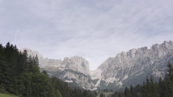 ワイルドカイザー チロルで有名なElmauer Torの遅い上昇ドローンショット オーストリア ヨーロッパで曇りの日に山脈の麓に沿って鬱蒼とした森の低角度ショット — ストック動画