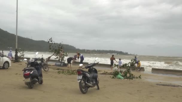 热带风暴过后的海浪前海滩上的人和摩托车 越南大农 — 图库视频影像