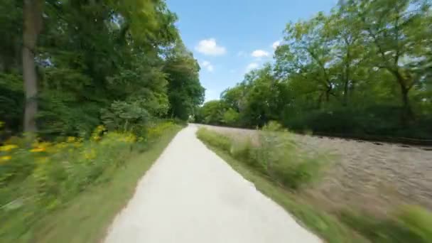 砕いた石灰岩の歩道を自転車で走ります 過去の鉄道のズーム 最初の人はPovサイクリングに乗ると実行を表示します シカゴ郊外のグレン滝森林保護区 — ストック動画