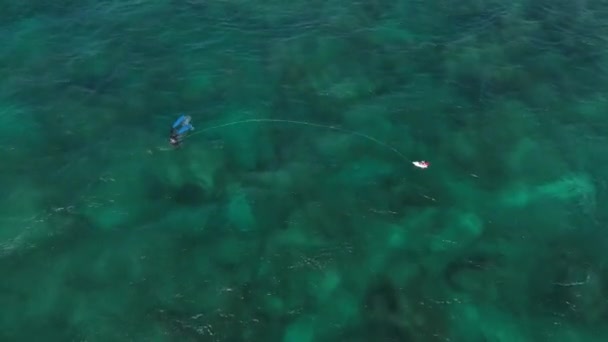 一本槍の漁師が岩の海の床に飛び込んで魚を捕る 空中上からの眺め — ストック動画