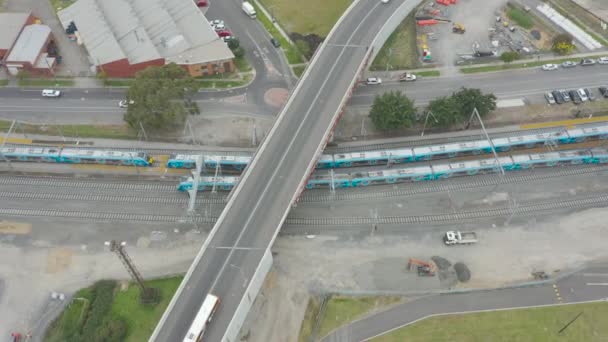 近代的な開発されたインフラと橋を渡って一緒に運転バスを介して移動する列車の空中平行追跡 — ストック動画
